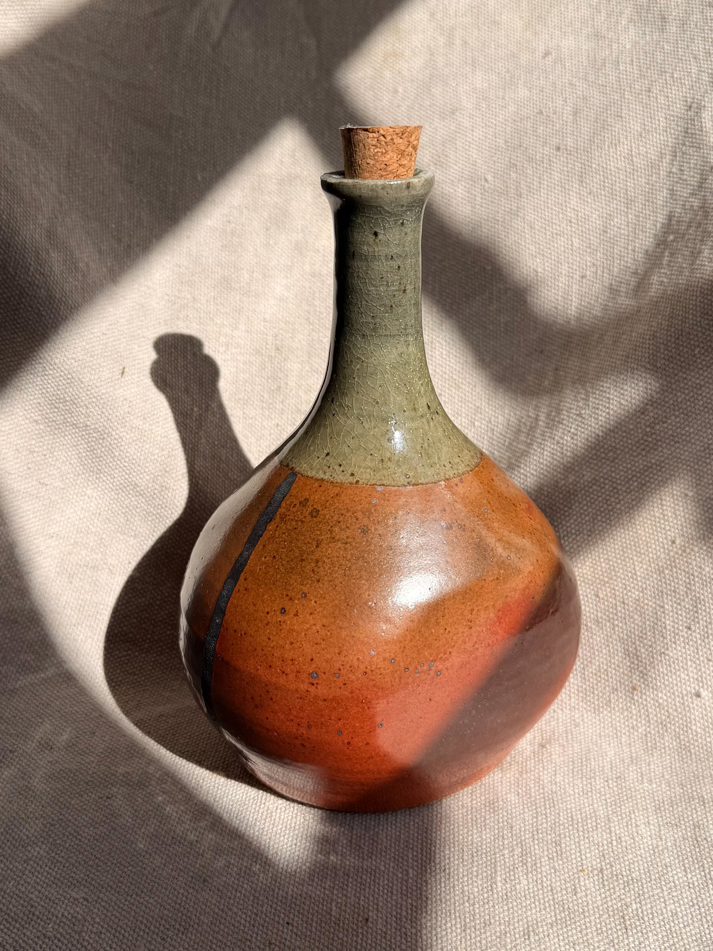 Ceramic bottle with a textured surface on a neutral background
