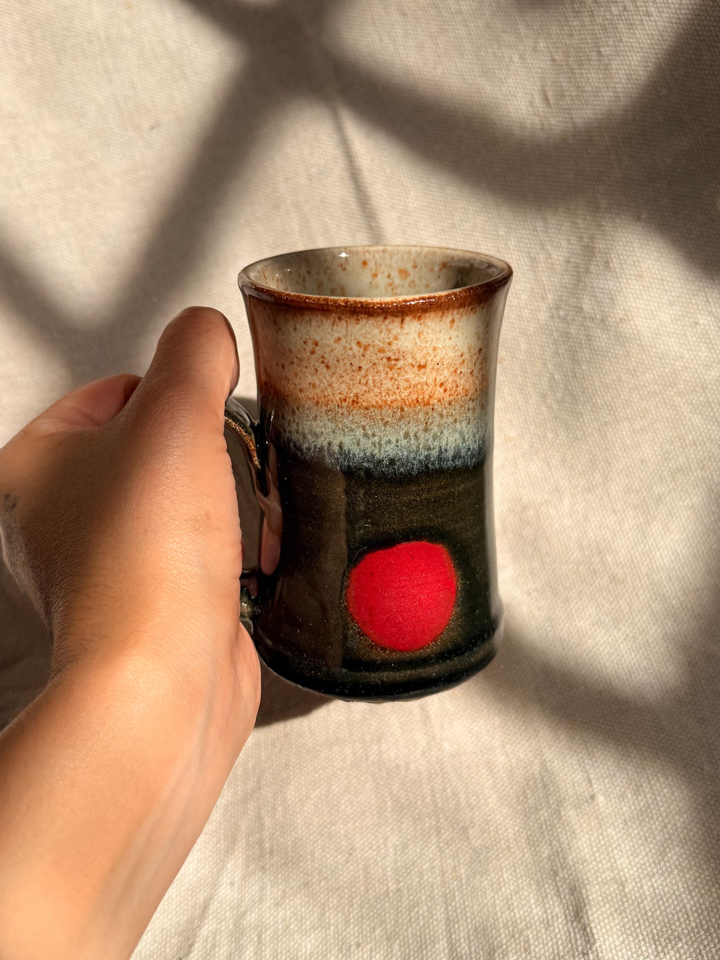 ceramic mug with red dot on it