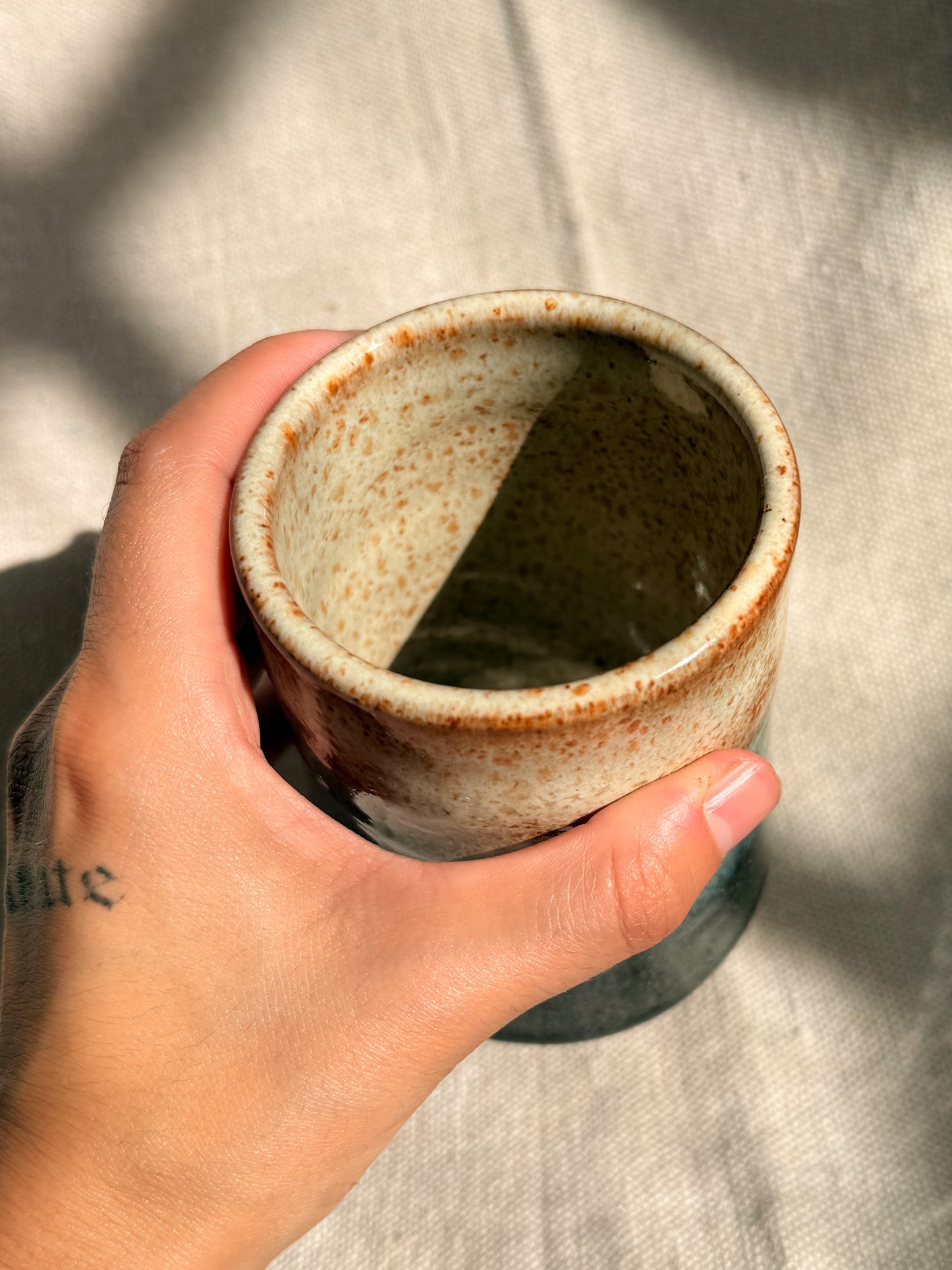 beige ceramic mug with black dot