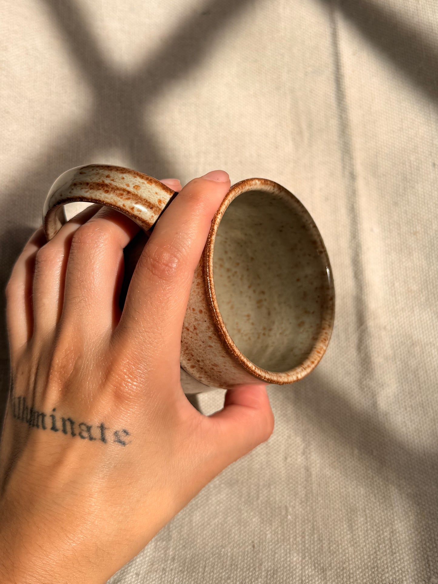 beige ceramic mug with blue dot