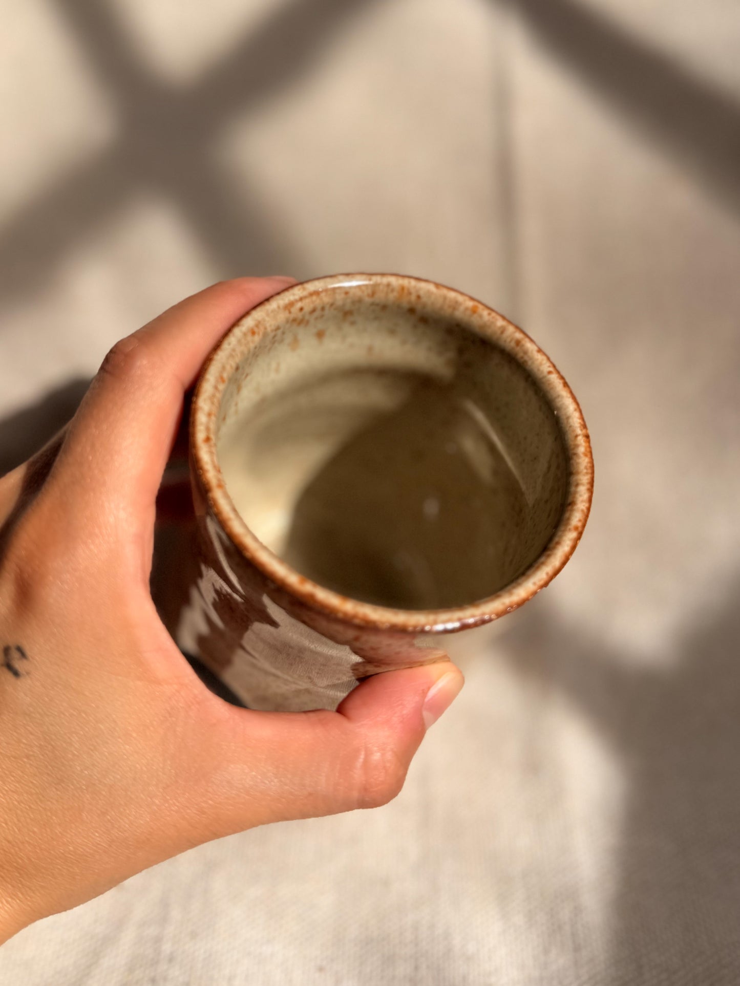 beige ceramic mug with black dot