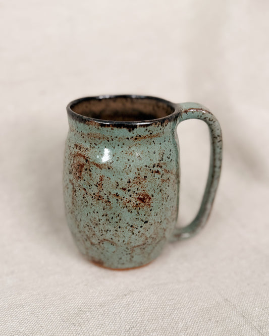 Speckled blue mug on a light fabric background