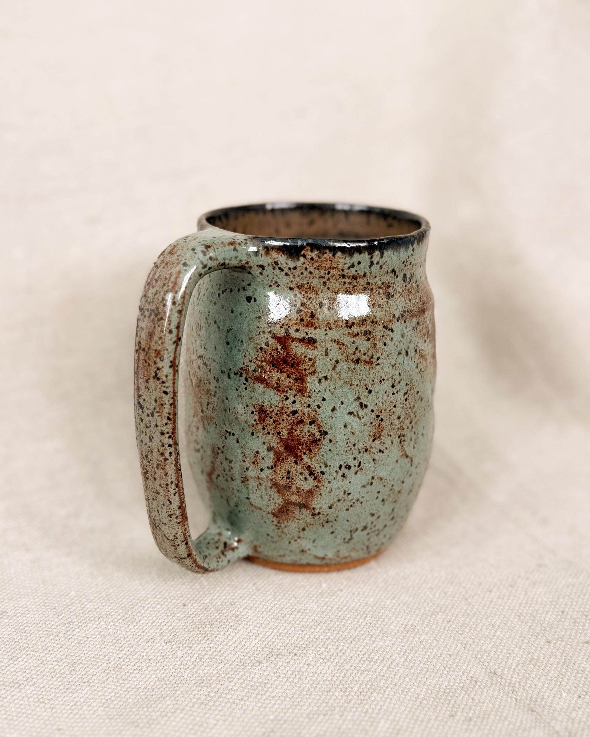 Speckled ceramic mug on a beige background