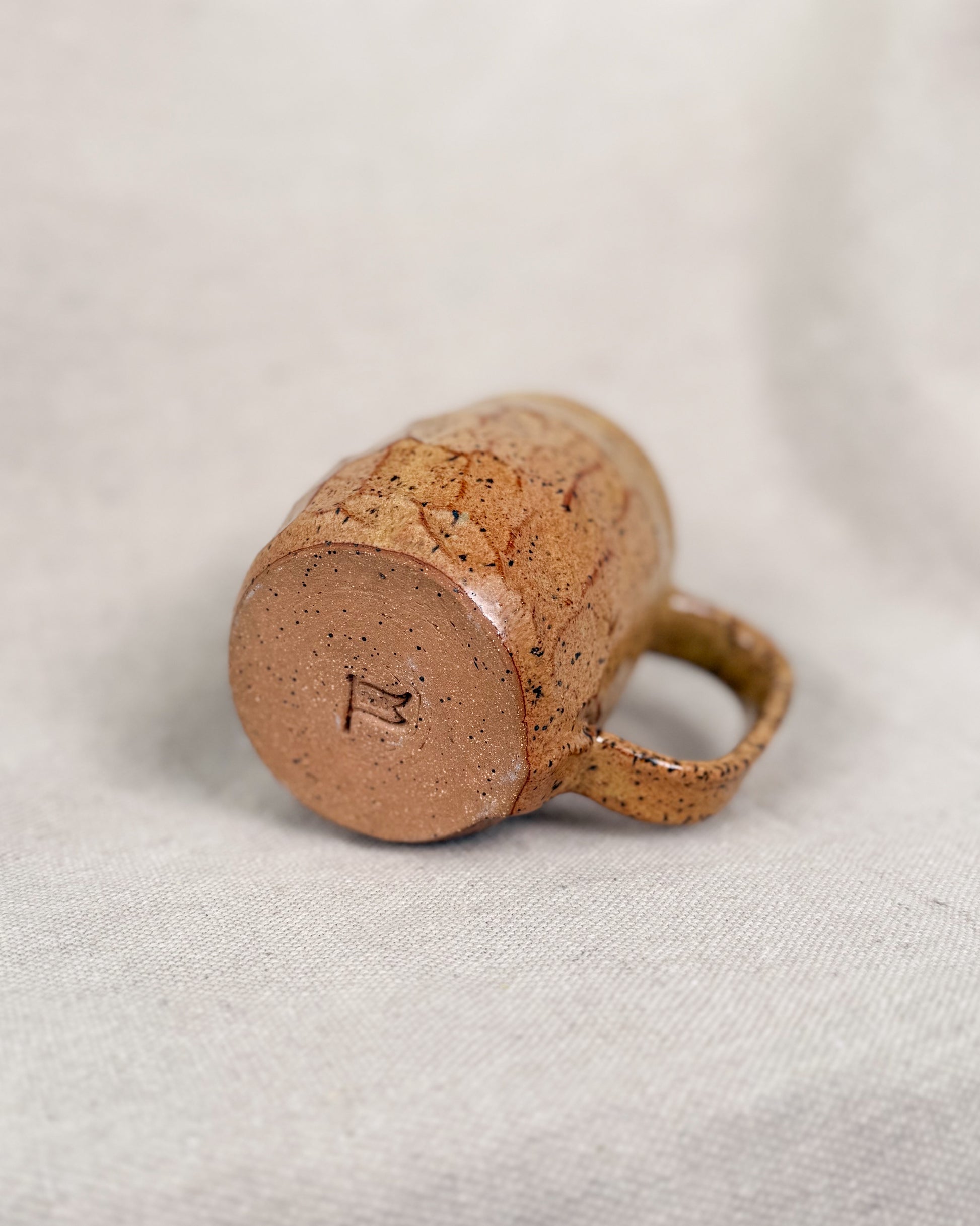 Ceramic mug with a textured surface on a light fabric background
