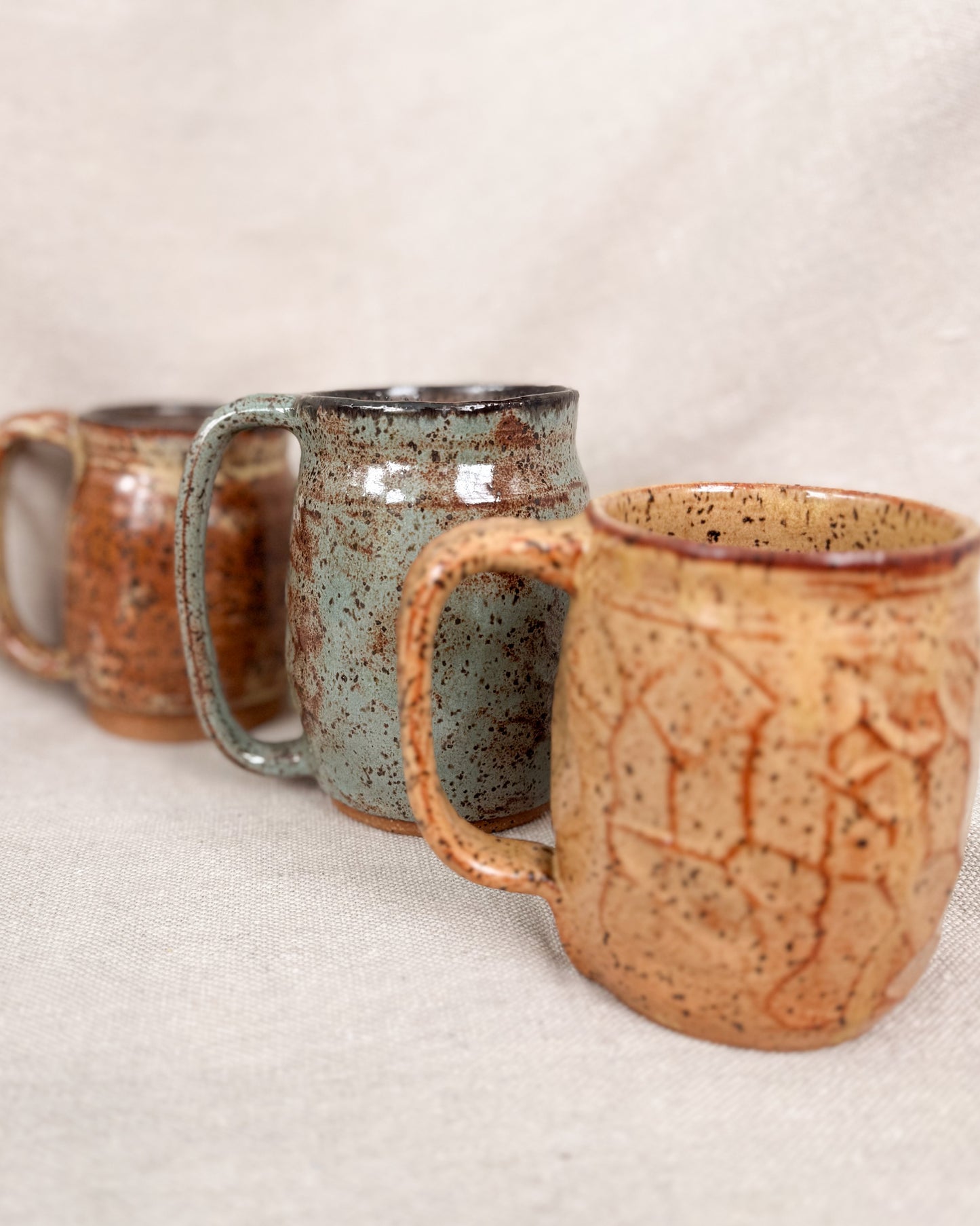 Three ceramic mugs with textured surfaces on a light background