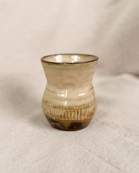 Small ceramic vase with textured surface on a beige fabric background, 10 ounce 