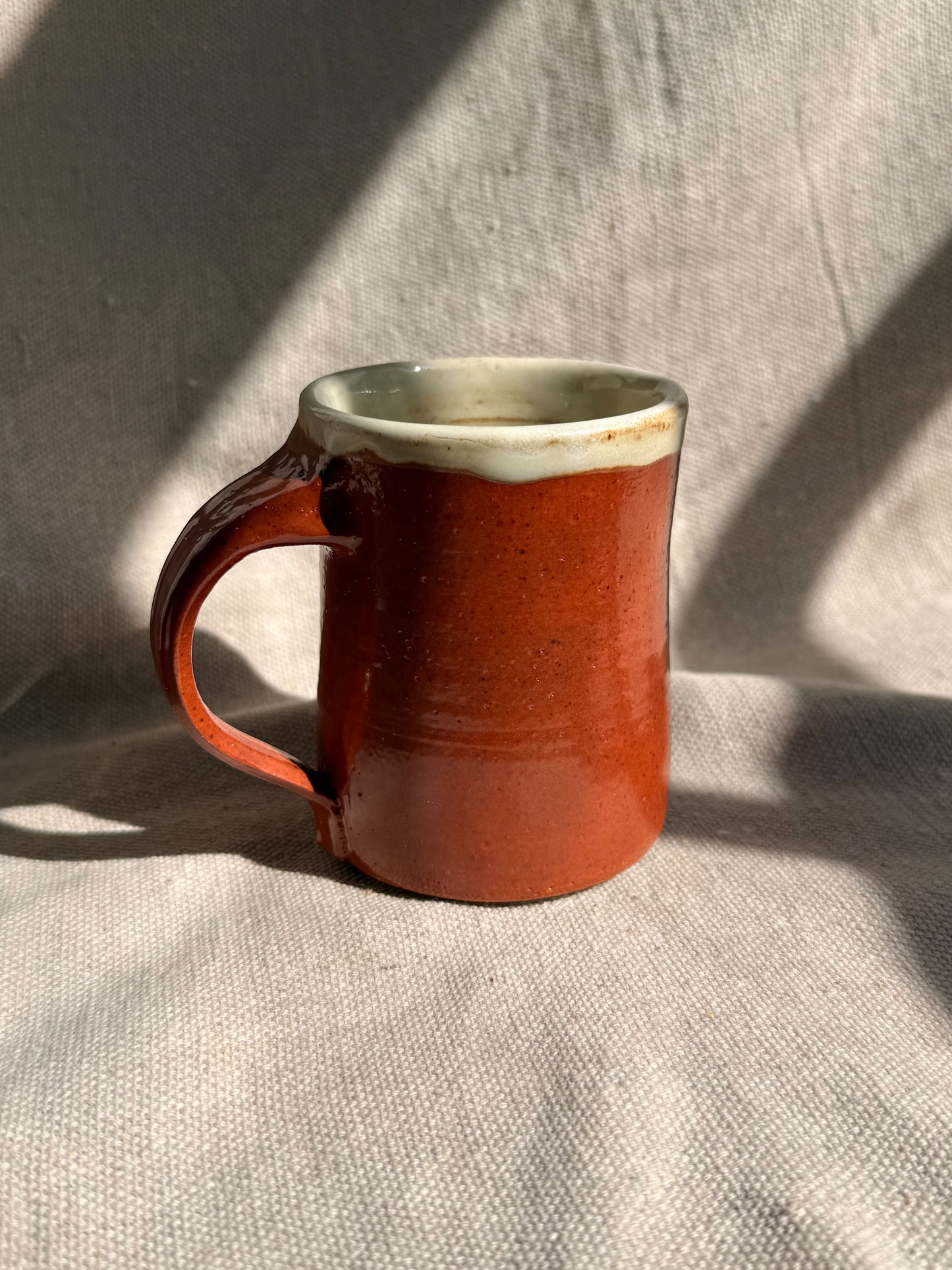 red ceramic mug on a textured gray surface