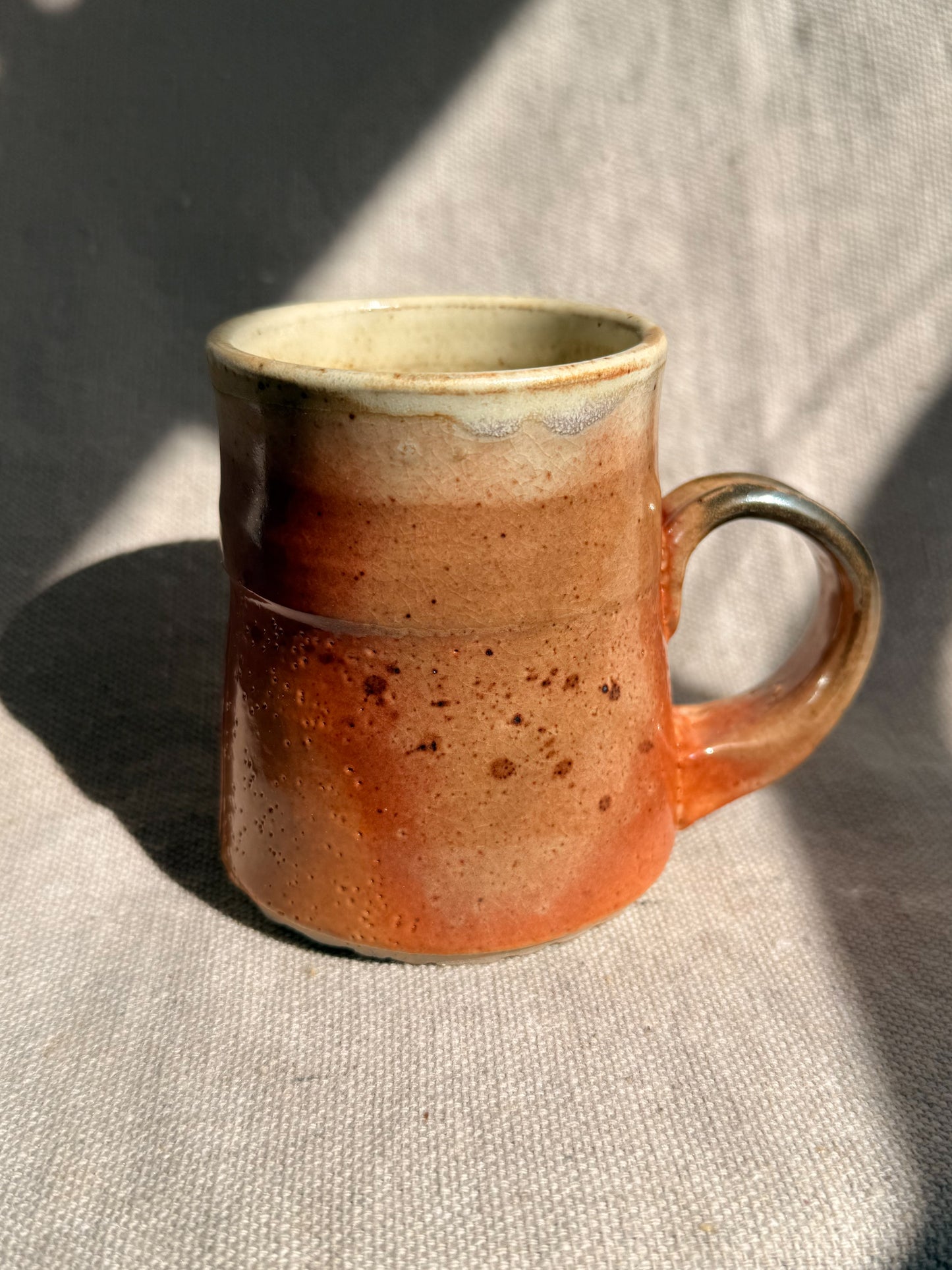 Ceramic mug with speckled design on a textured surface