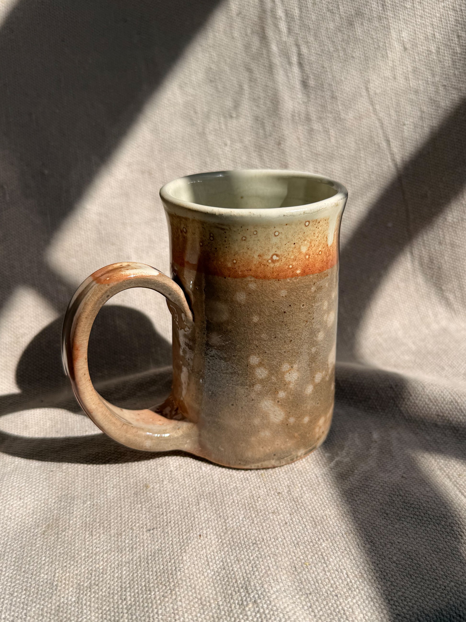 Ceramic mug with a gradient finish on a textured fabric background