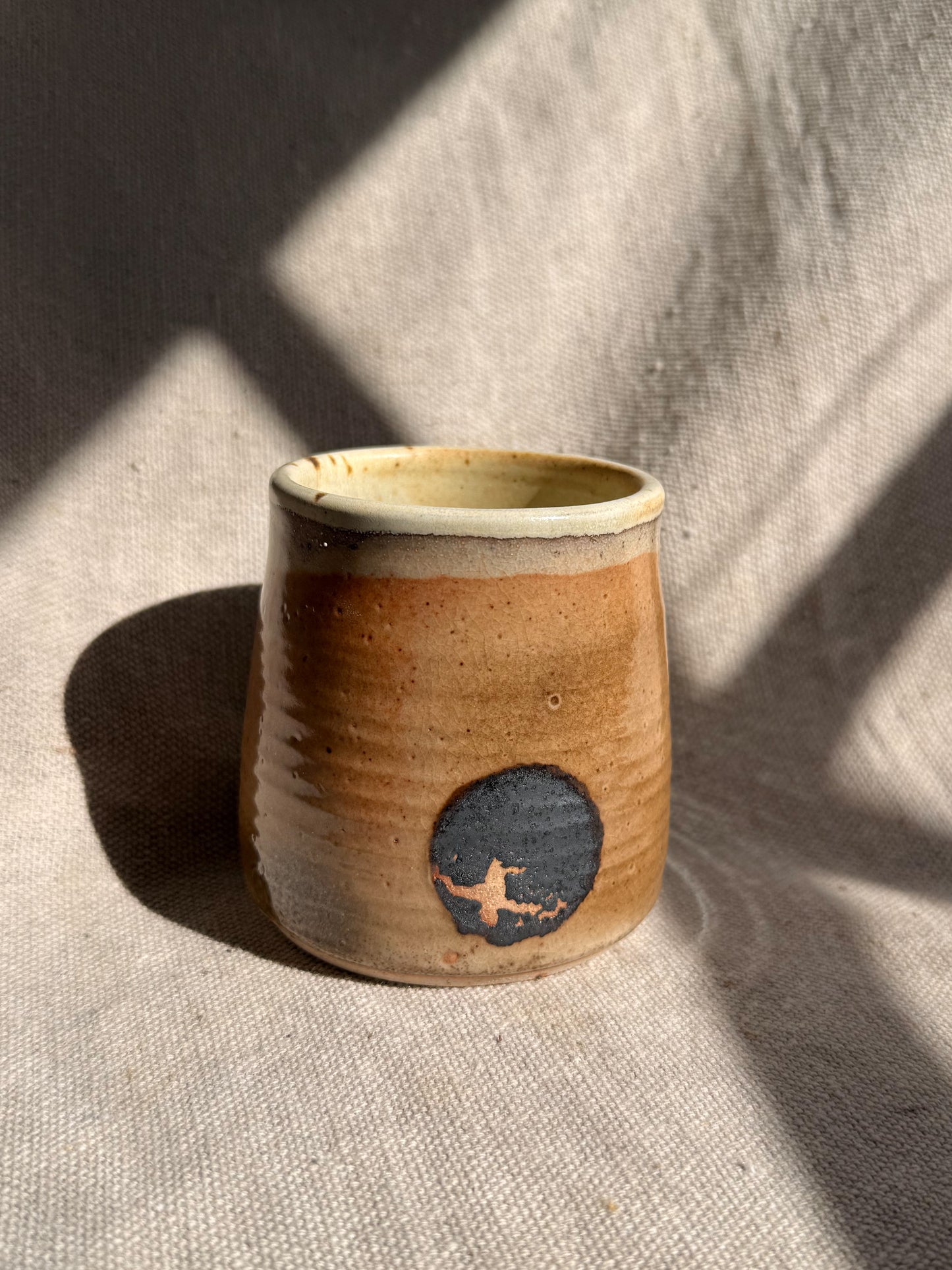 Ceramic cup with a blue design on a textured beige surface