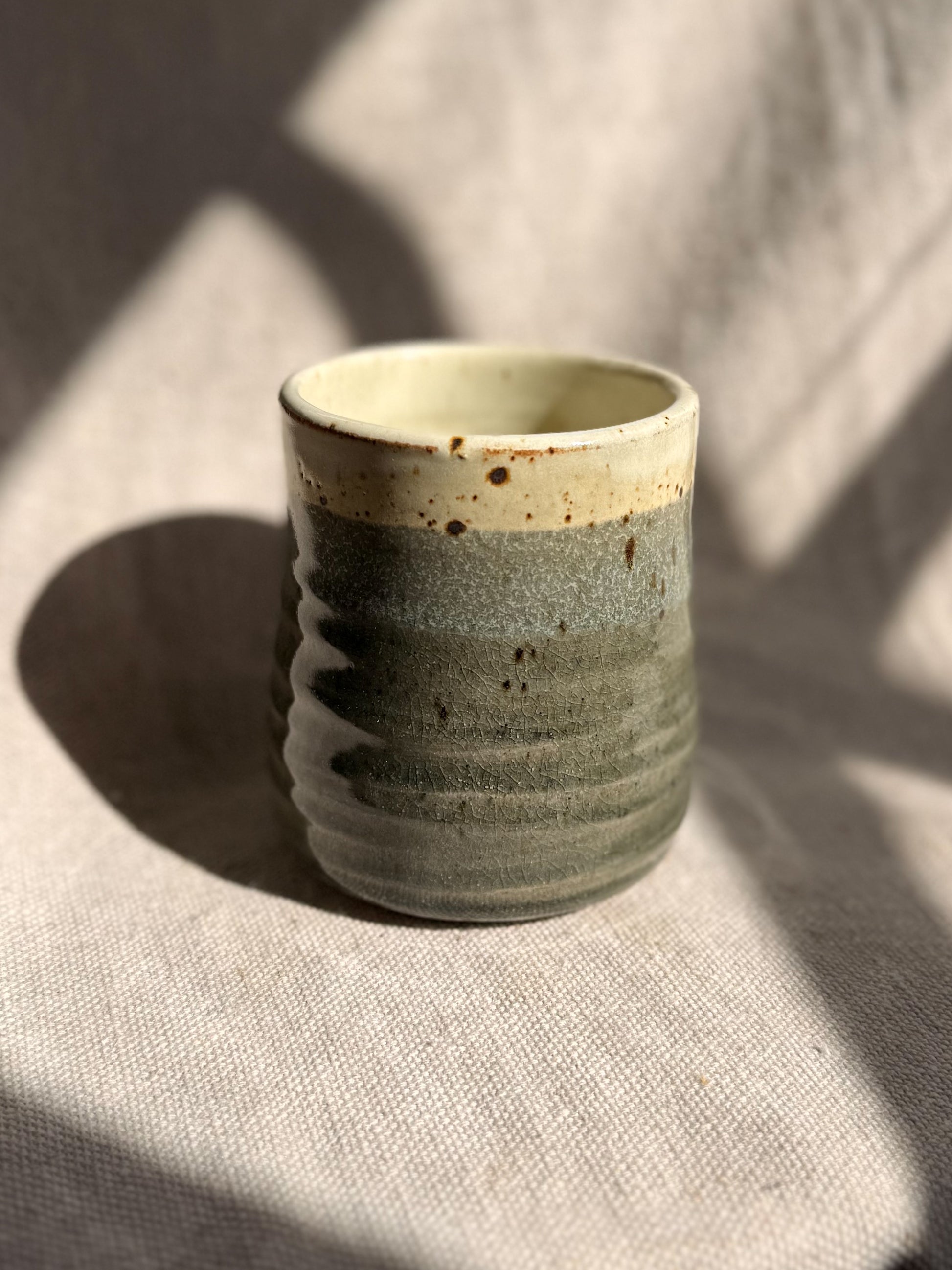 Ceramic cup with textured surface on a textured surface