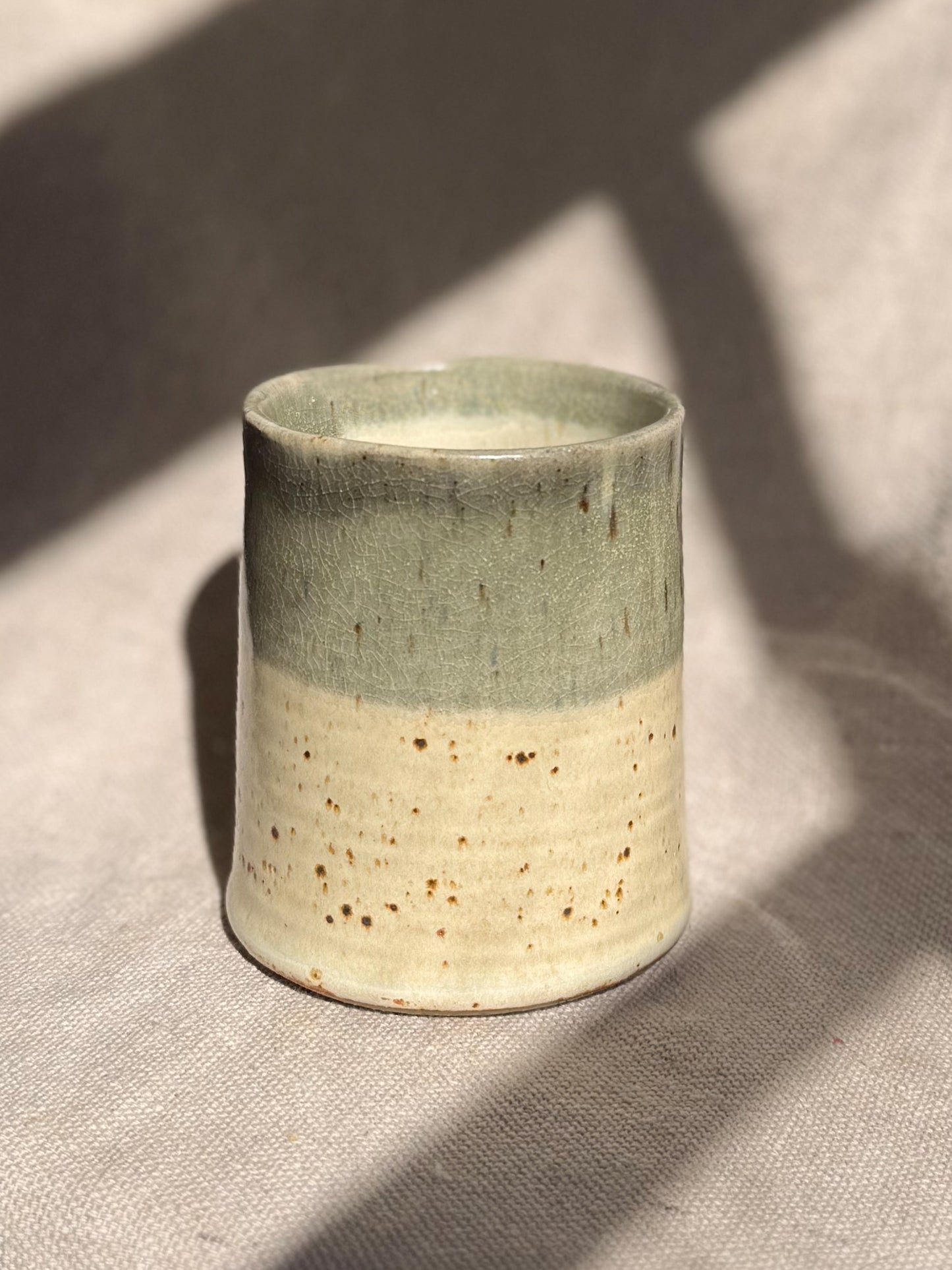Ceramic cup with two-tone design on a textured surface