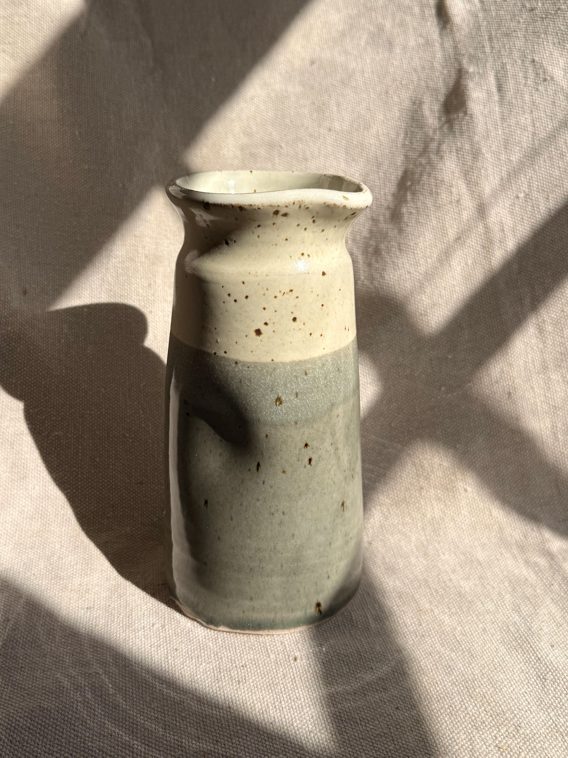 Ceramic vase with two-tone design on a textured surface