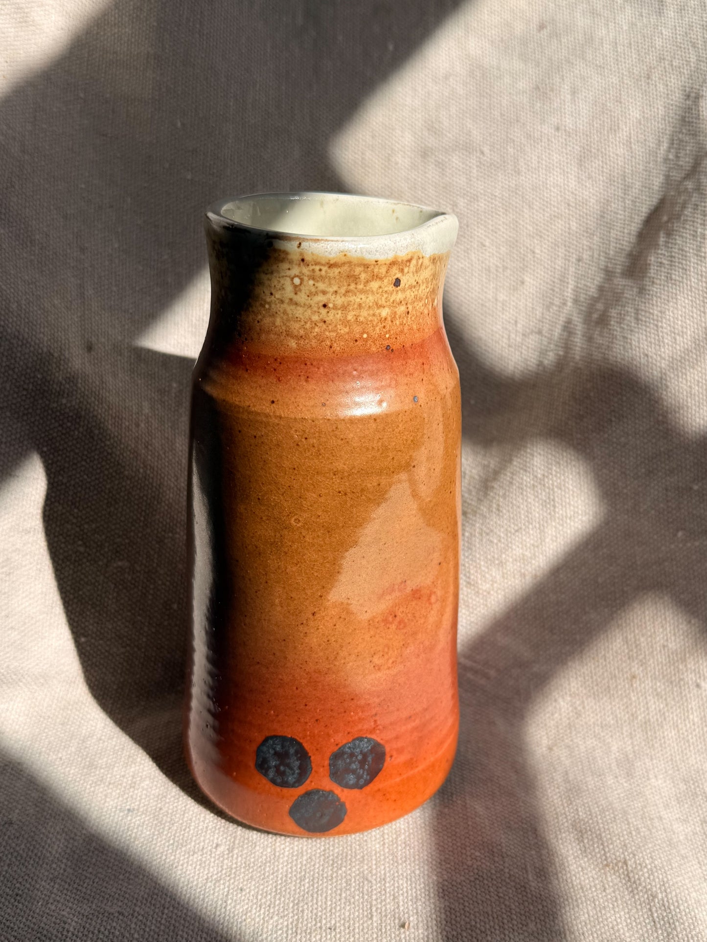 Cylindrical ceramic vase with a gradient finish on a textured surface