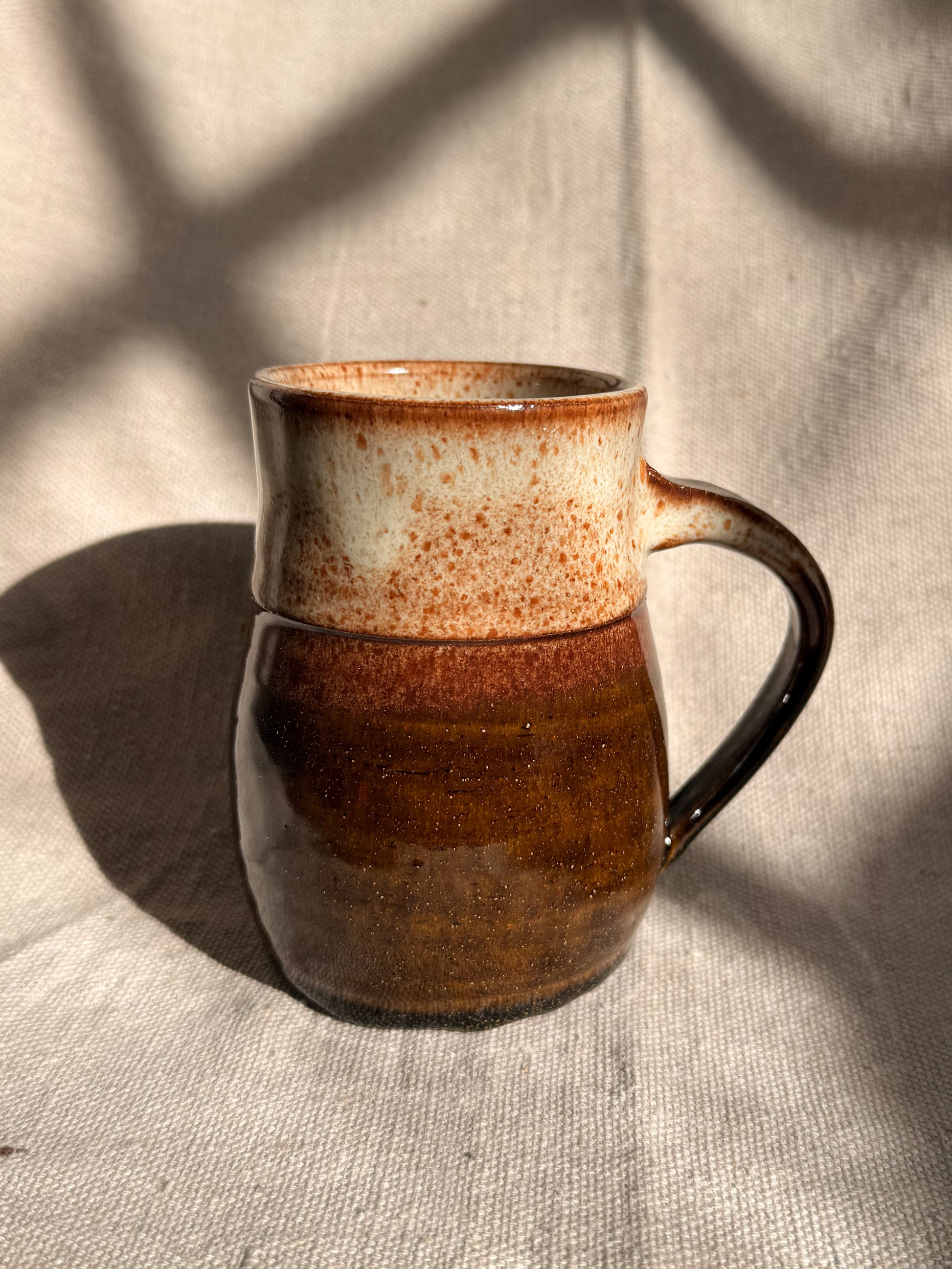 brown ceramic mug with blue dot 