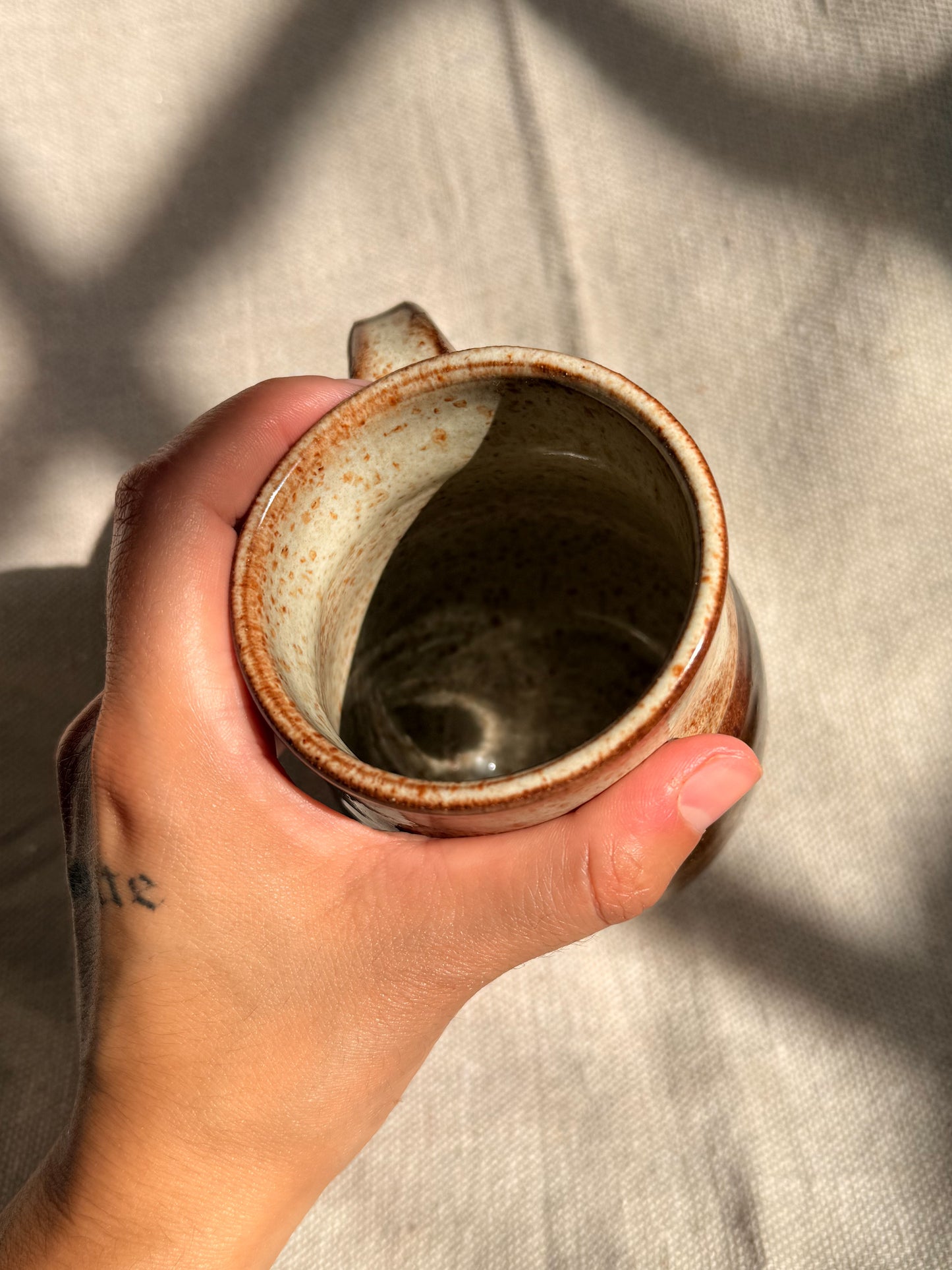 brown ceramic mug with blue dot 