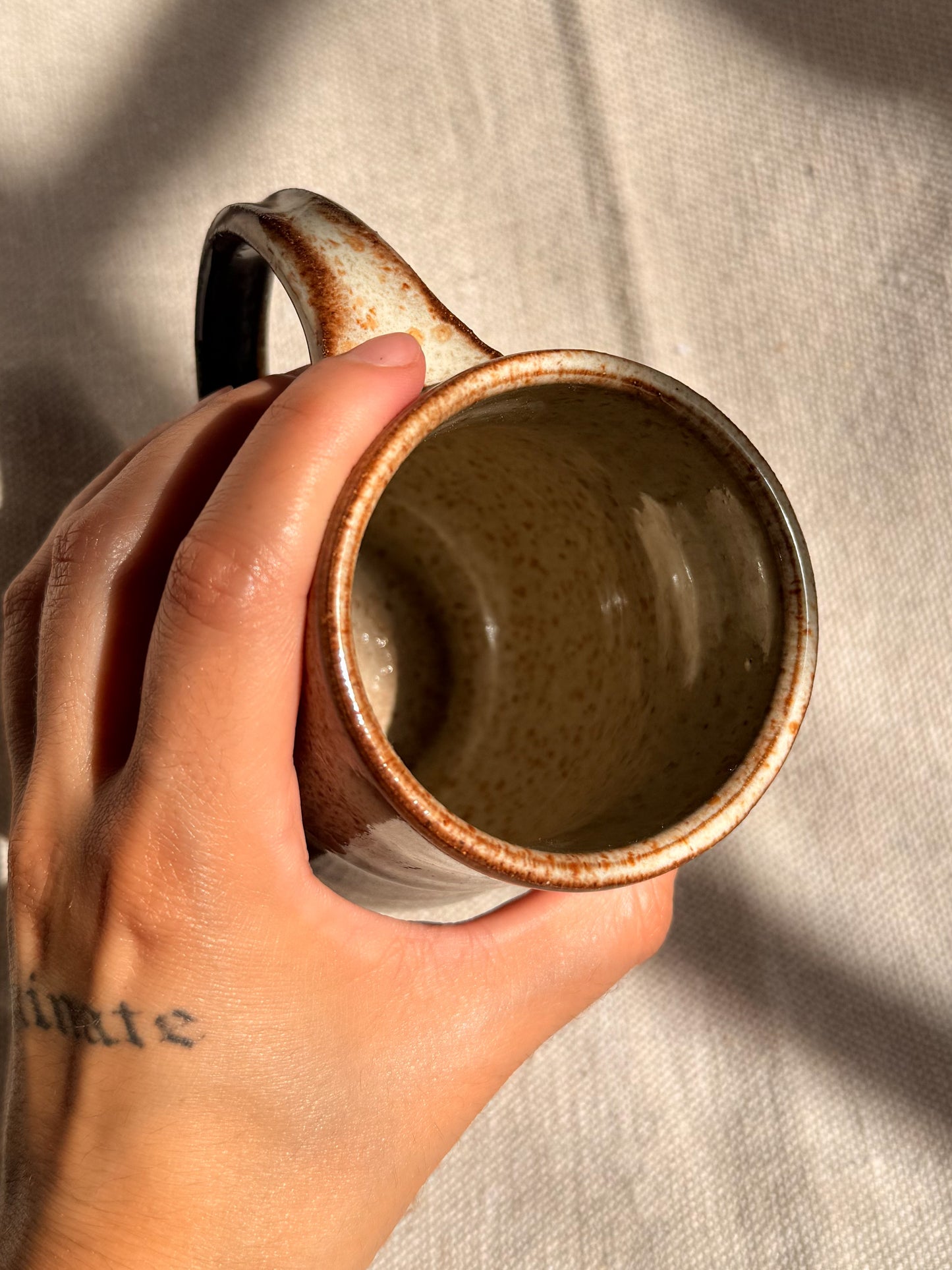 brown ceramic mug with blue dot 