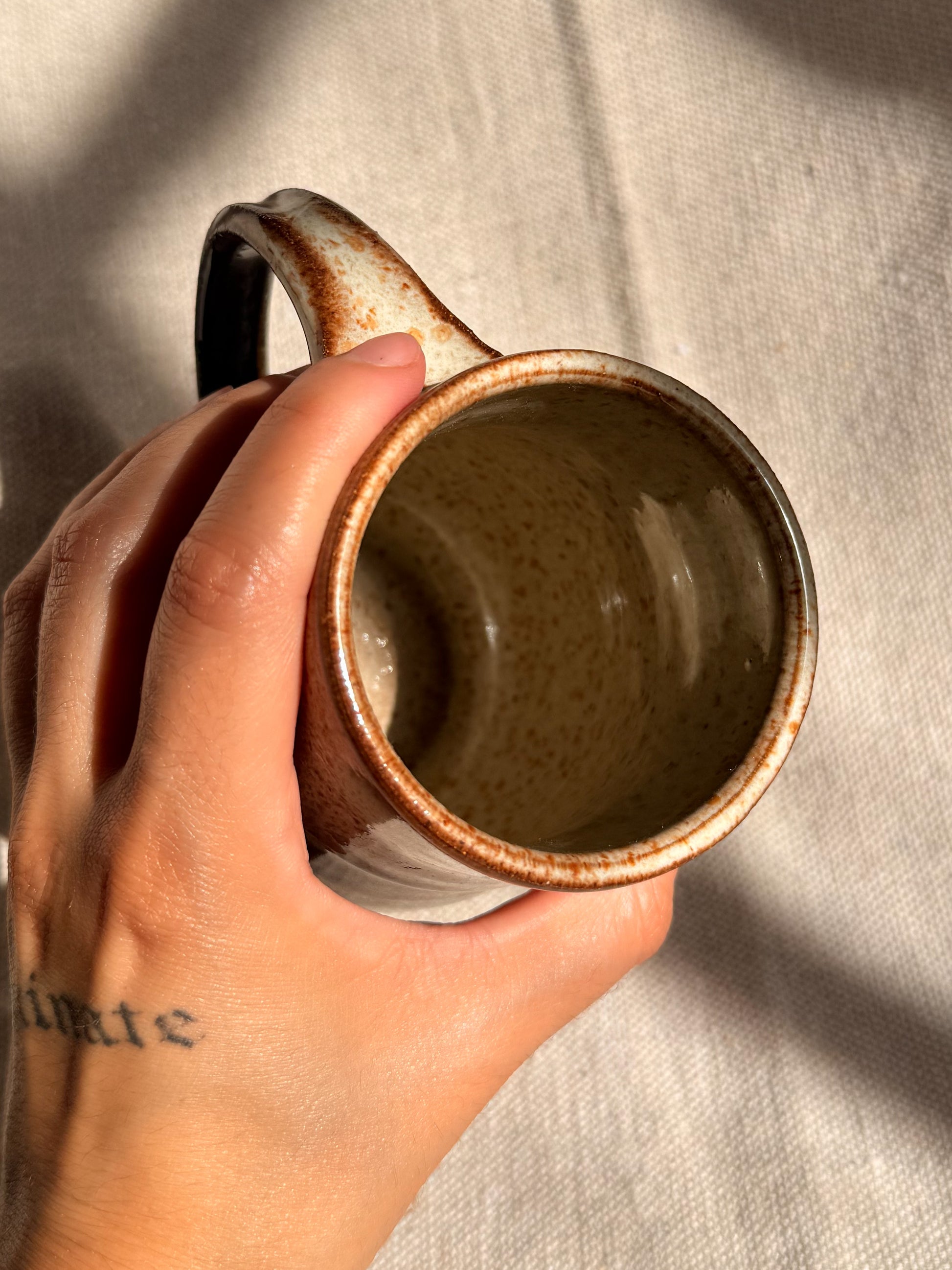 brown ceramic mug with blue dot 