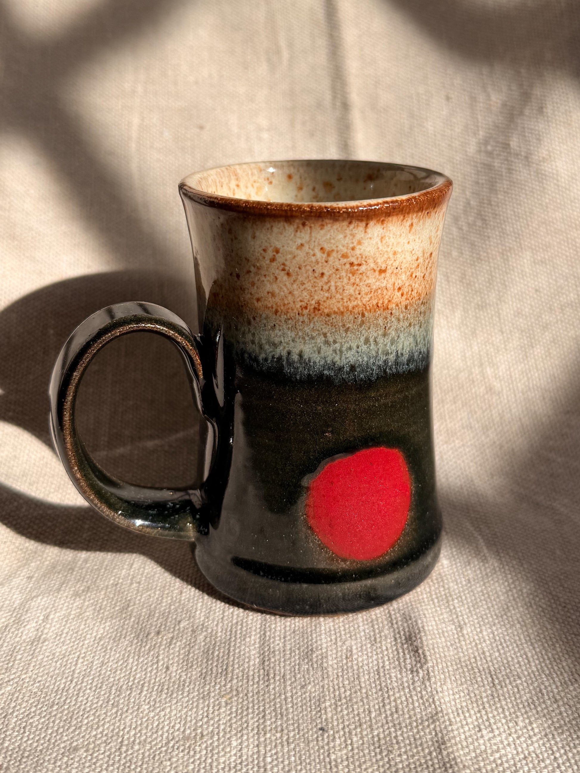 ceramic mug with red dot on it 