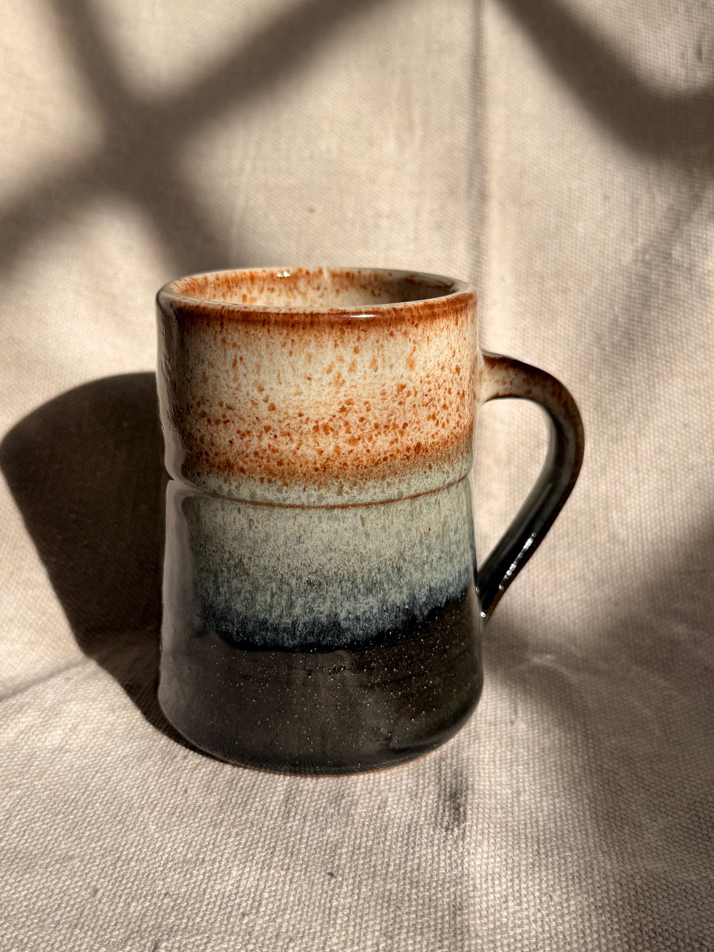 beige ceramic mug with black dot 