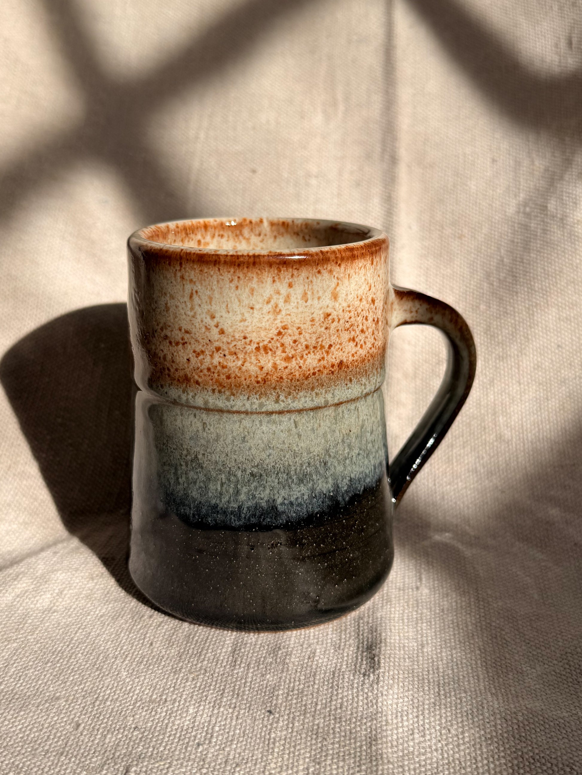 beige ceramic mug with black dot 