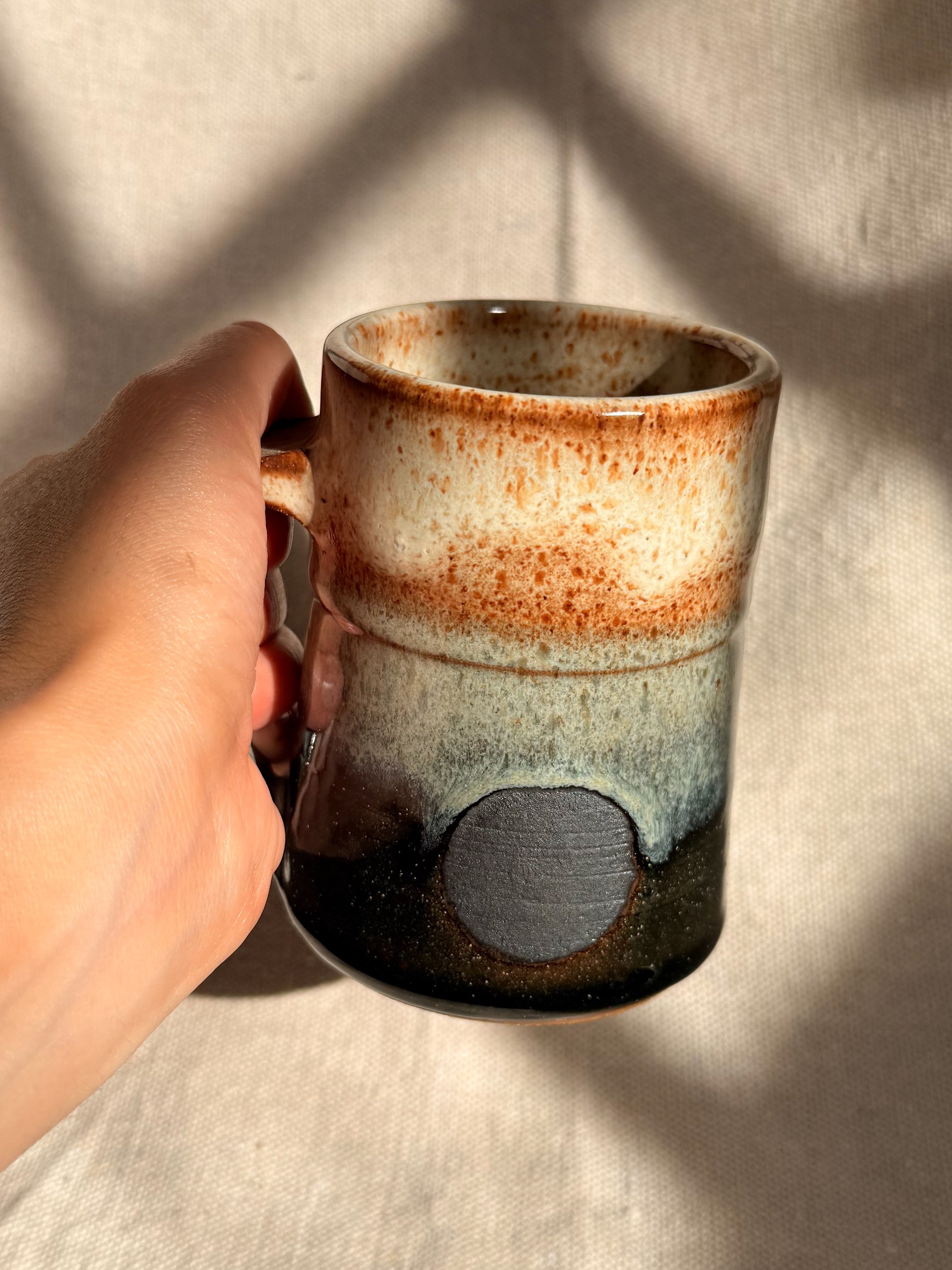 beige ceramic mug with black dot 
