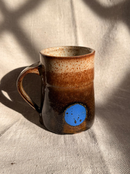 brown ceramic mug with blue dot 