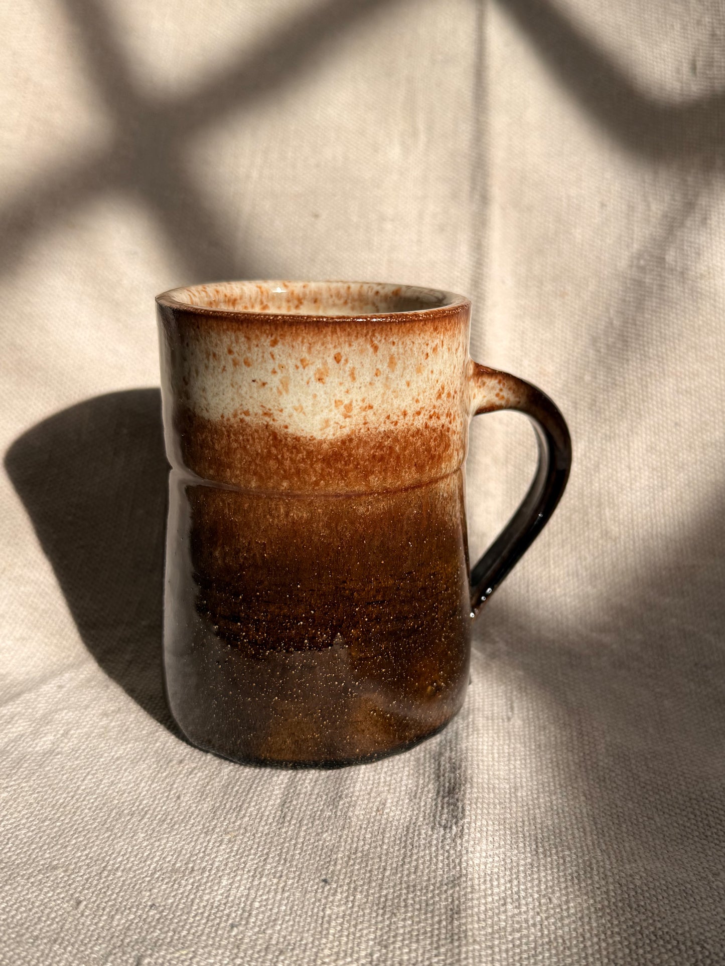 brown ceramic mug with blue dot 