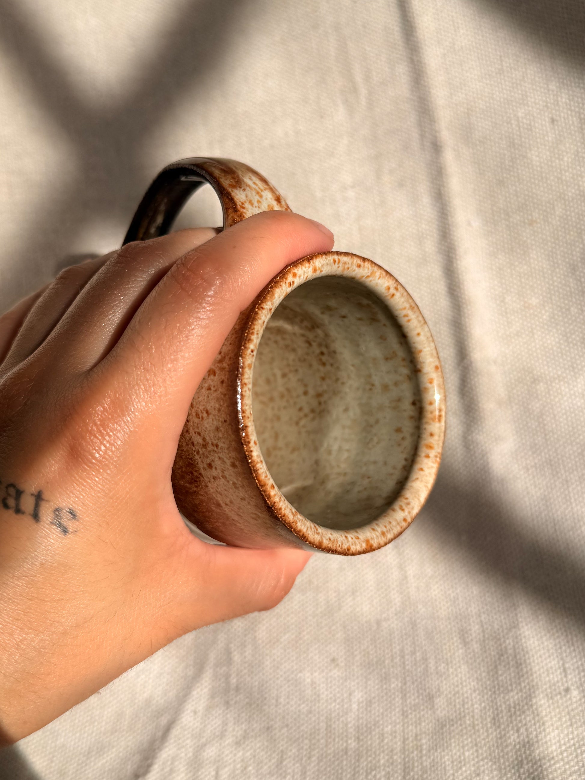 brown ceramic mug with blue dot 