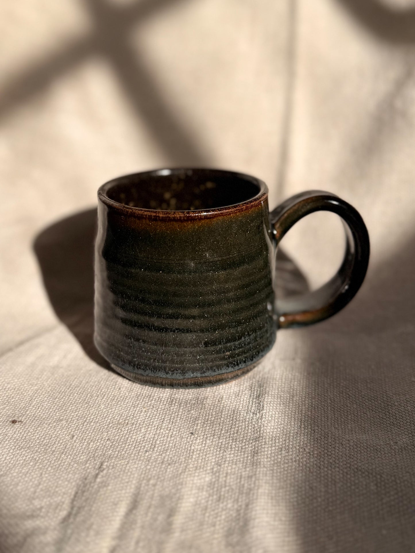 brown ceramic mug with red dot 