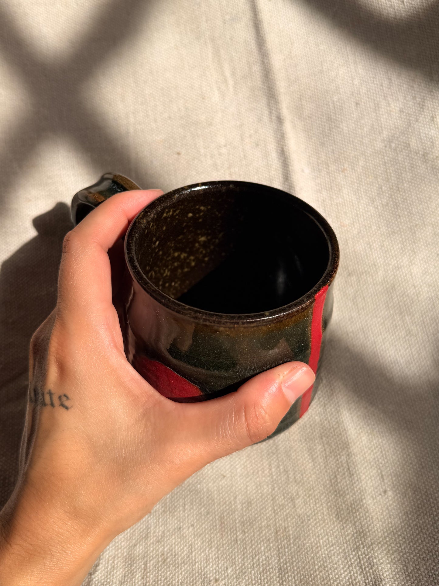 brown ceramic mug with red dot 