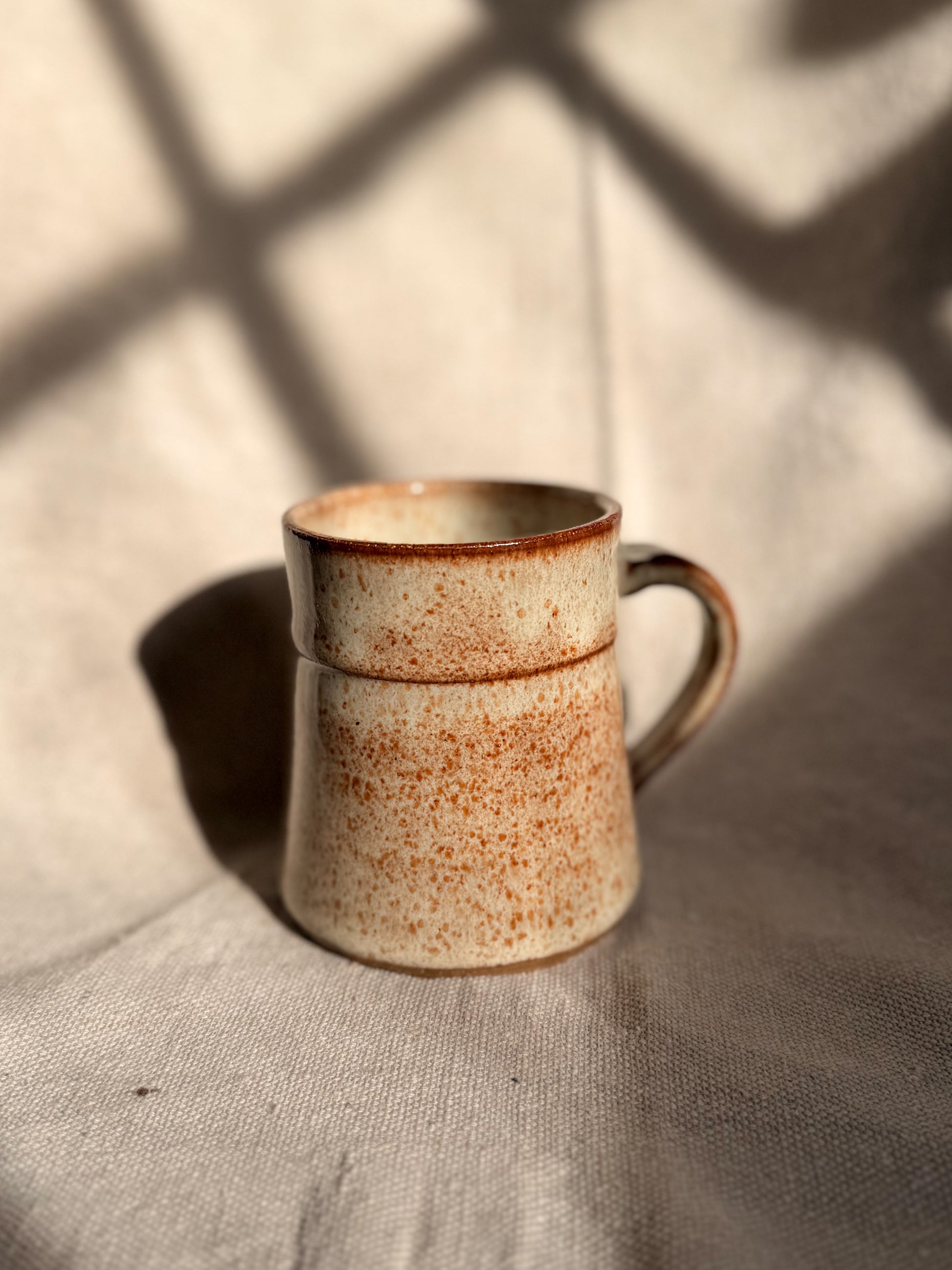 beige ceramic mug with blue dot 