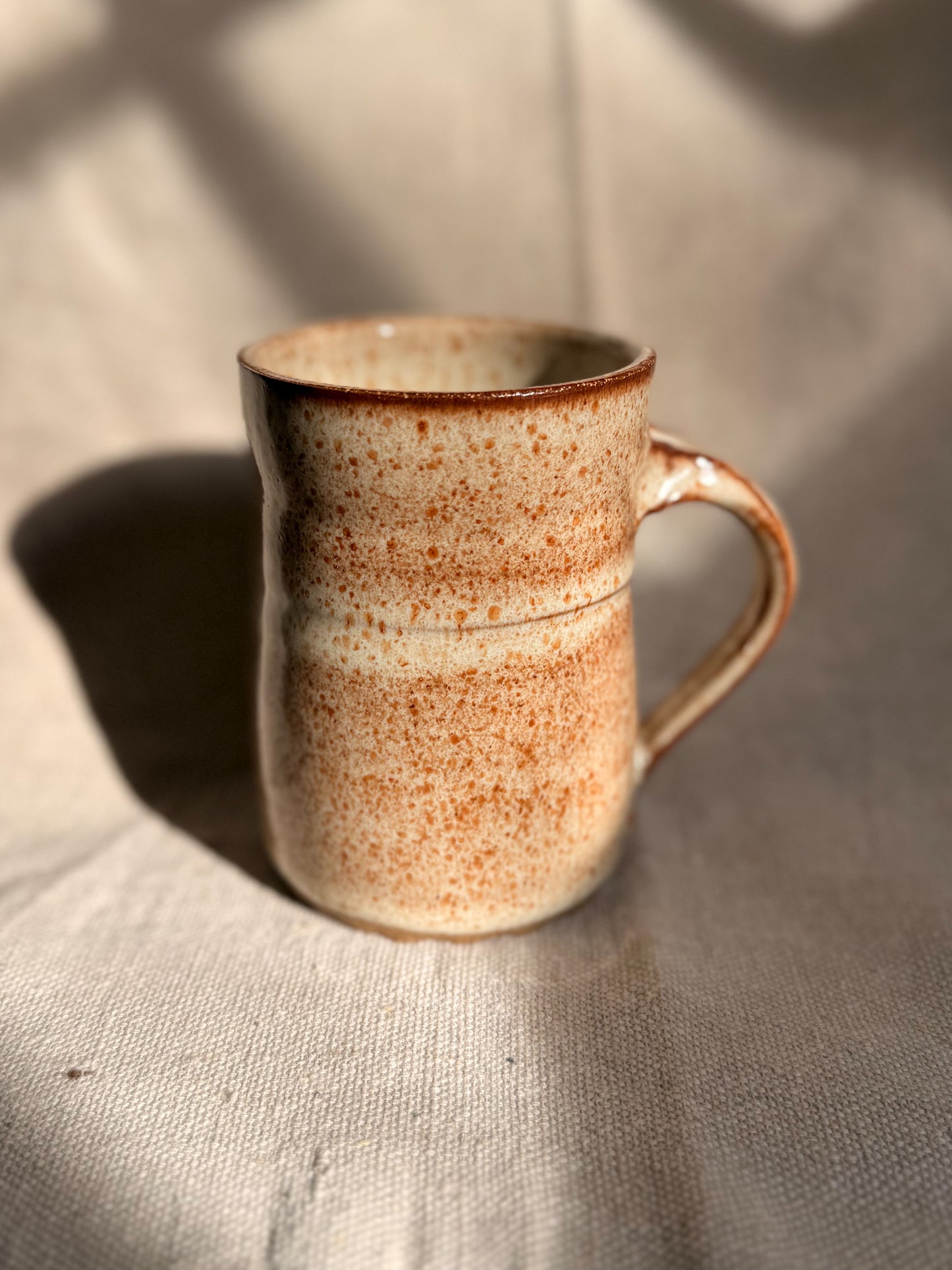 beige ceramic mug with black dot 