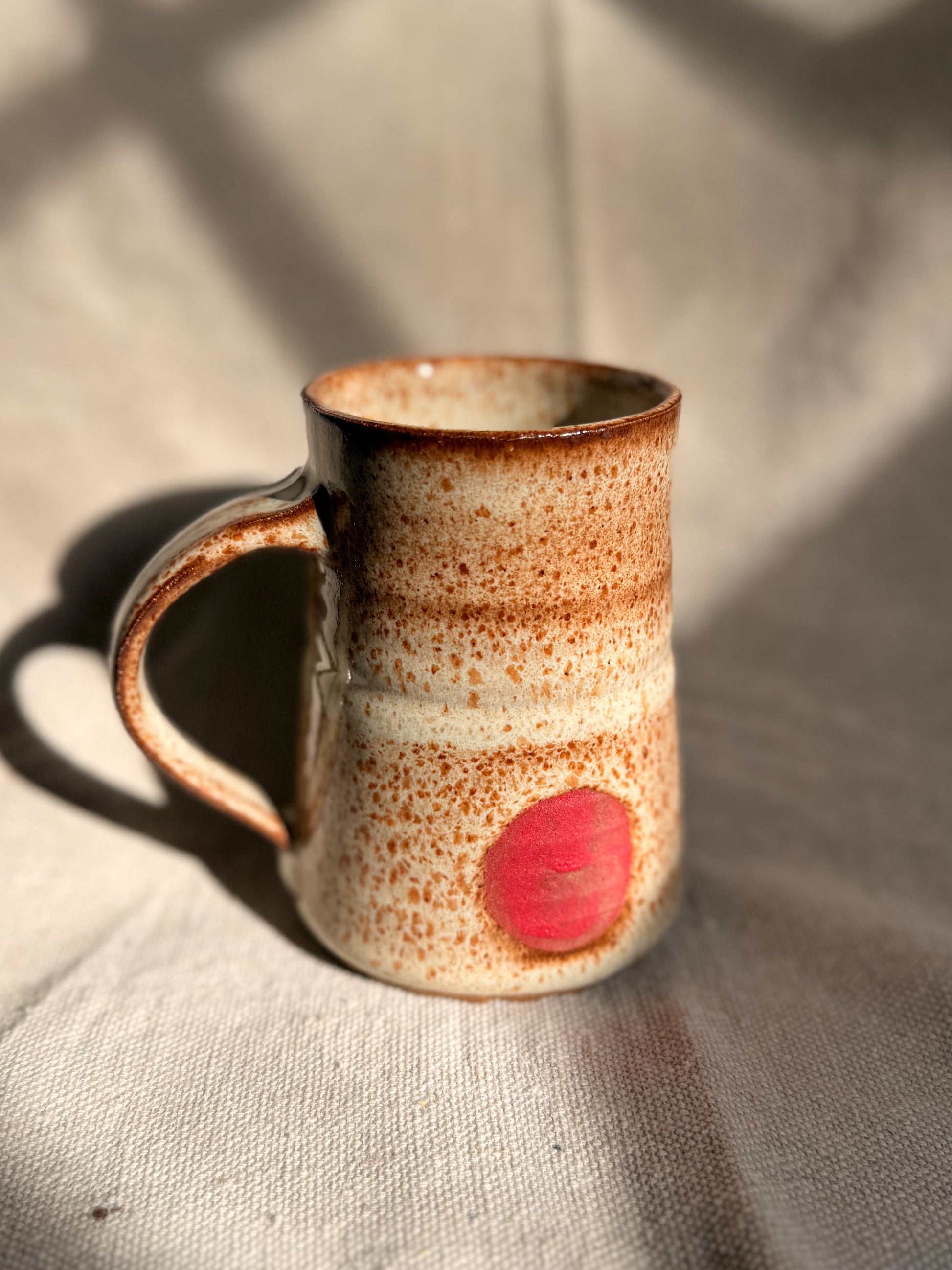 beige mug with red dot with a canvas background
