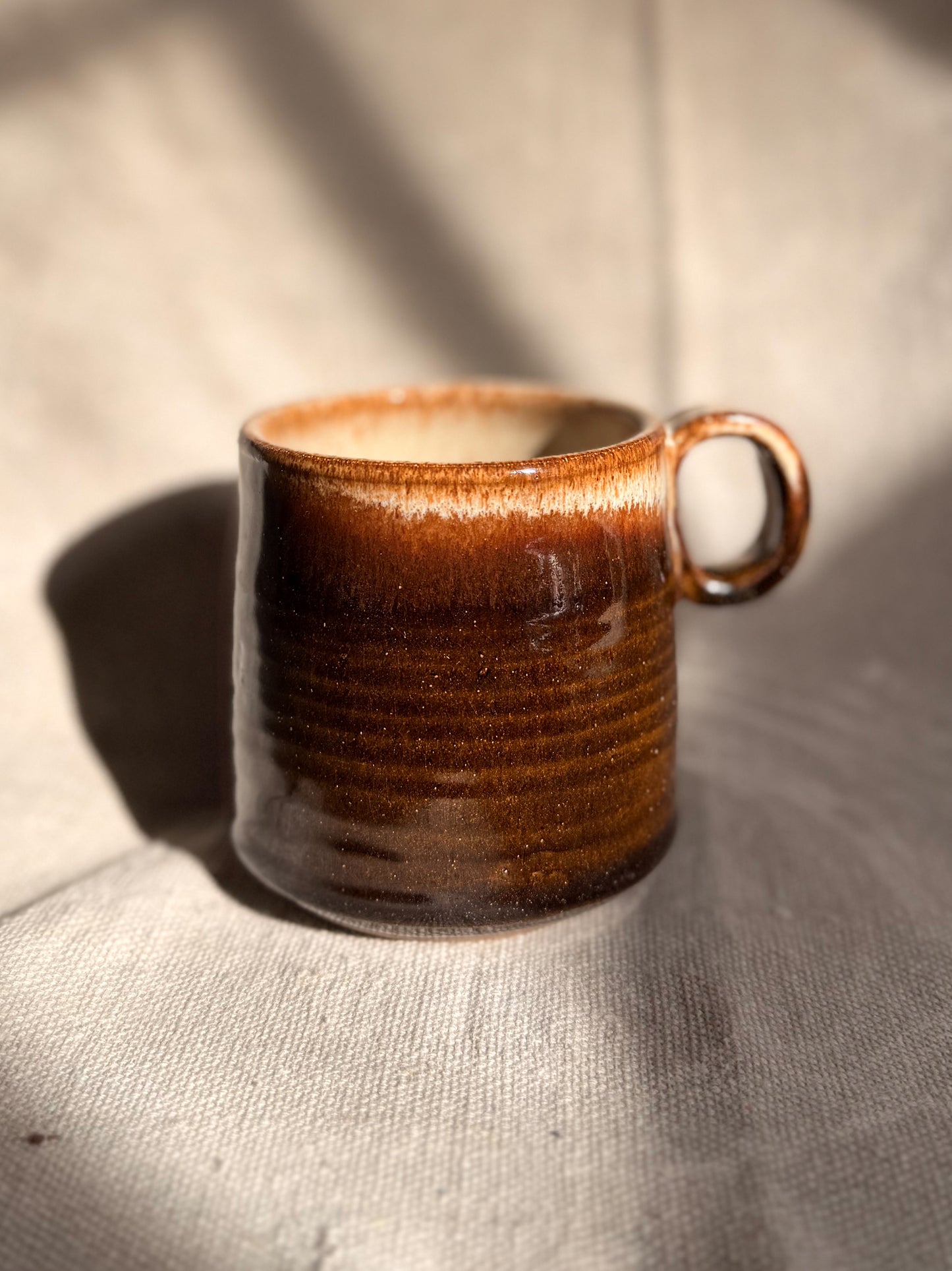 brown ceramic mug with red dot